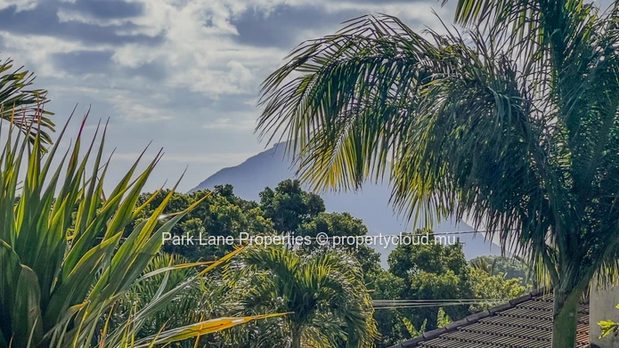 Maison familiale avec jardin arboré à Floréal – Cadre paisible, sécurité renforcée et vue montagne