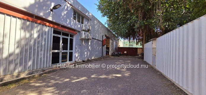 This unfurnished industrial building of 1300 m2 on a plot of land of 666 toises located in Pailles